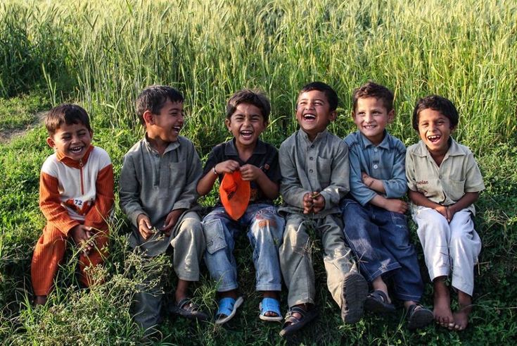 Pakistani children sharing a joyful moment in a green field
